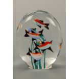 A vintage kitsch glass paperweight depicting fish surrounding seaweed, 10 cm