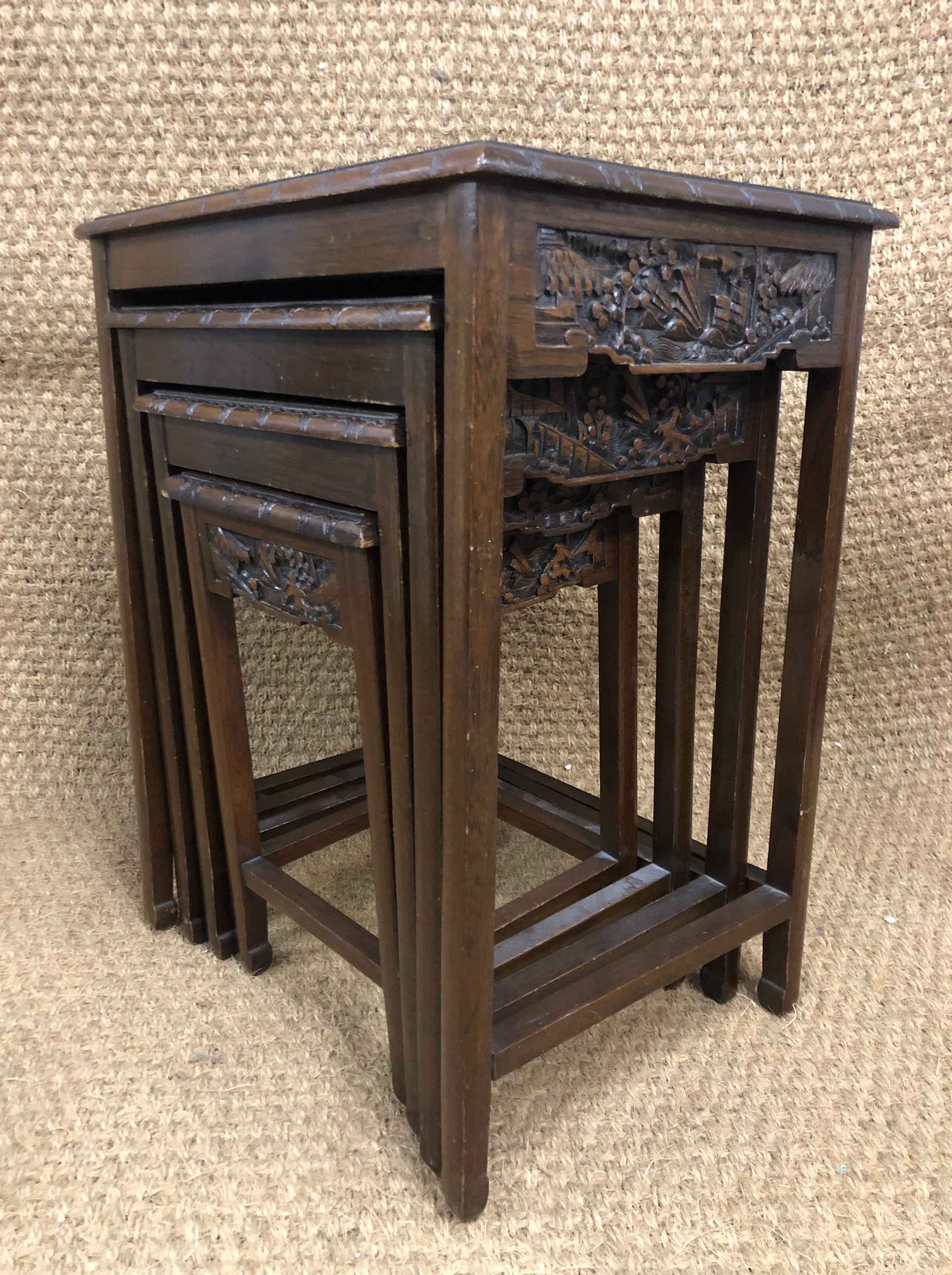 An early 20th Century Chinese carved hardwood nest of tables, 53 cm x 39 cm x 67 cm high