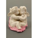 A Victorian fairing match holder and striker, modelled as a pair of cupids embracing beside a