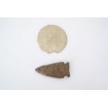 A stone arrowhead, Neolithic / early native American, together with a fossil urchin, former 5 cm