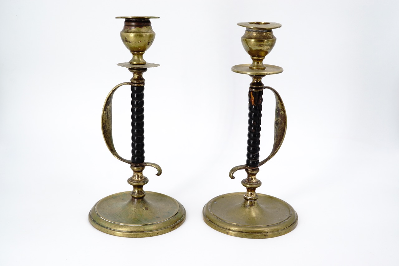 A pair of brass and turned wood candlesticks, their stems modelled as sword hilts, 21 cm