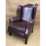 A pair of contemporary brown hide upholstered wing-back armchairs