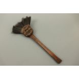 An early 20th Century novelty carved wooden brush, its head depicting a grotesque mask with bristles