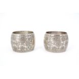 A pair of Victorian silver drum form napkin rings, profusely foliate engraved and bearing vacant
