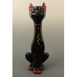A 1960s continental European kitsch Siamese cat figurine, in black with red and yellow highlights,