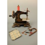 An early 20th Century German tinplate toy sewing machine, hand-driven, circa 1920, with