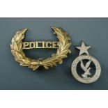 An early 20th Century US police cap badge together with a Ghana Police badge