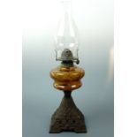 A Victorian oil lamp, having a glass reservoir and cast pyramidal base, 47 cm high