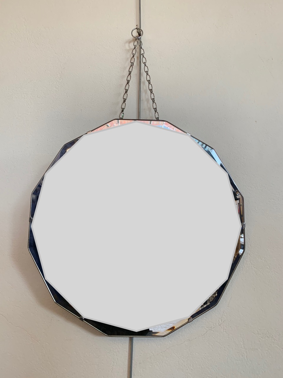 A bevel edged polygonal wall mirror circa 1930s - 1950s, 46 cm diameter