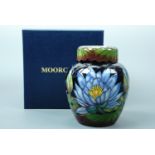 A contemporary Moorcroft covered jar, the decoration depicting blue lotus blossom over a black