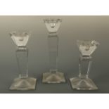 Three contemporary pressed glass statement candlestick holders, of graded height and square section,