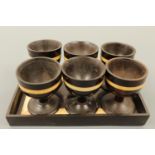 A set of six Anglo-Indian ivory and ebony egg cups and stand, late 19th / early 20th Century