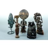 Four African carved figures together with an African candle holder