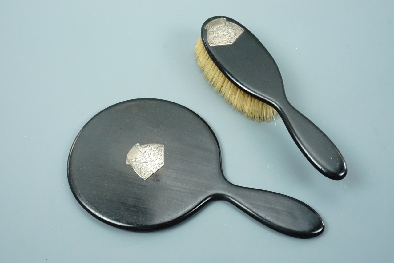 An early George V silver mounted ebony mirror and brush set, having foliate engraved decoration, H F