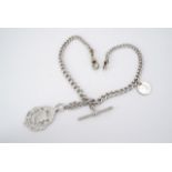 An antique silver double graded curb link watch chain with T-bar, swivels, shield and coin fobs,