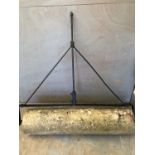 An antique wrought iron and sandstone garden roller