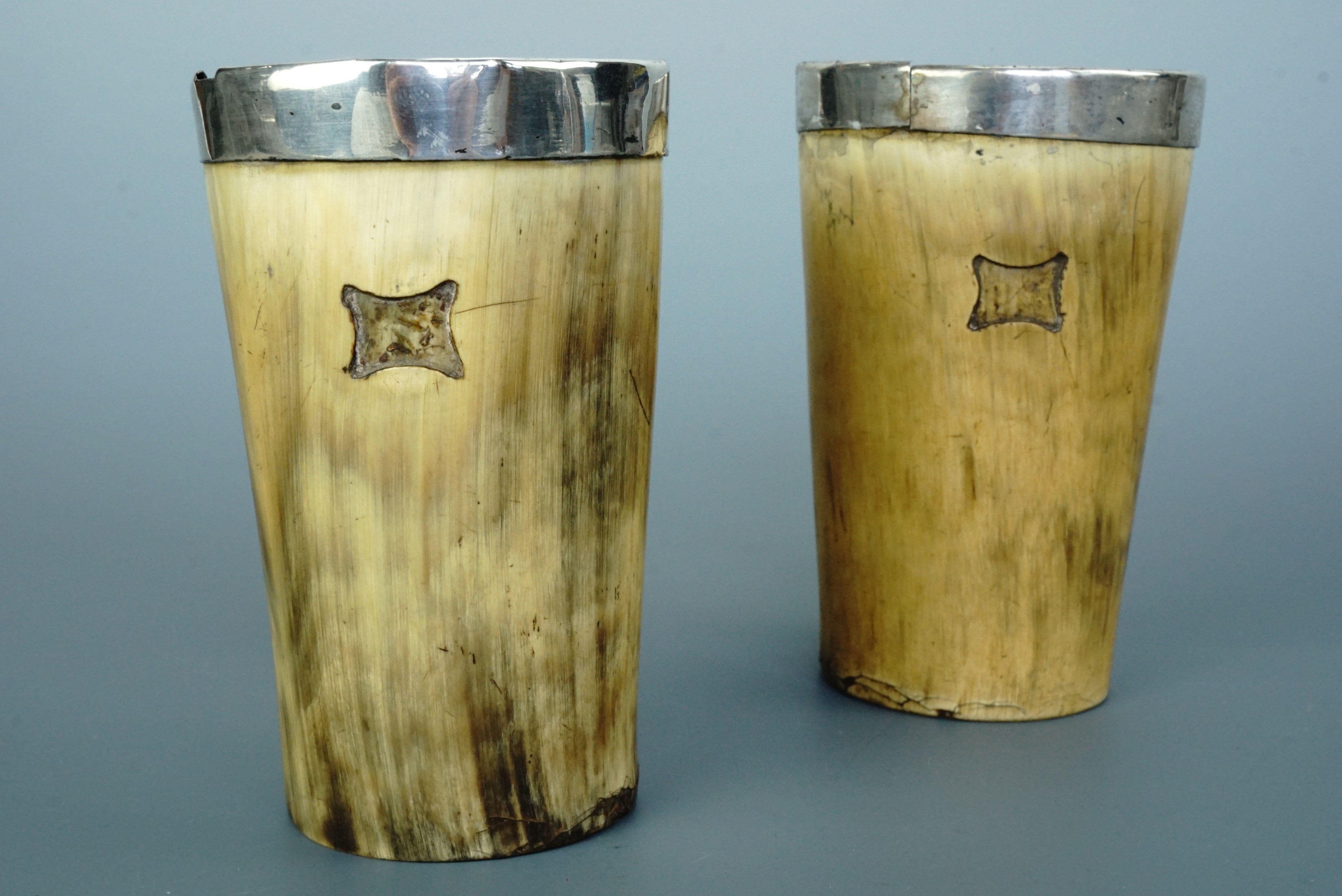 A 19th Century pair of white metal mounted horn beakers, 11 cm