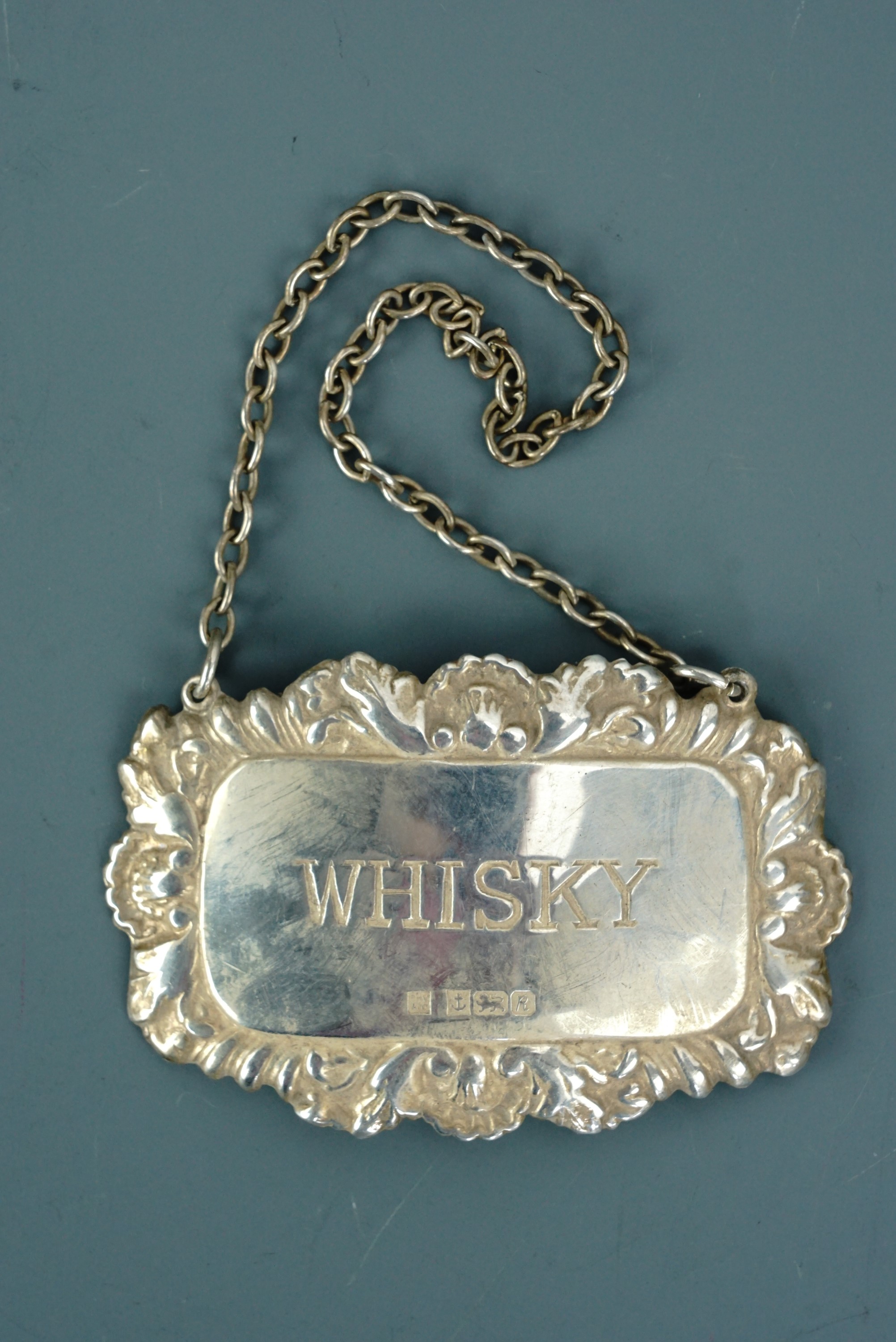A silver whisky decanter label