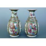 A pair of Chinese famille rose bottle vases, each with everted rims, decorated with figural scenes