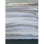 A quantity of antique and vintage white damask table cloths and napkins