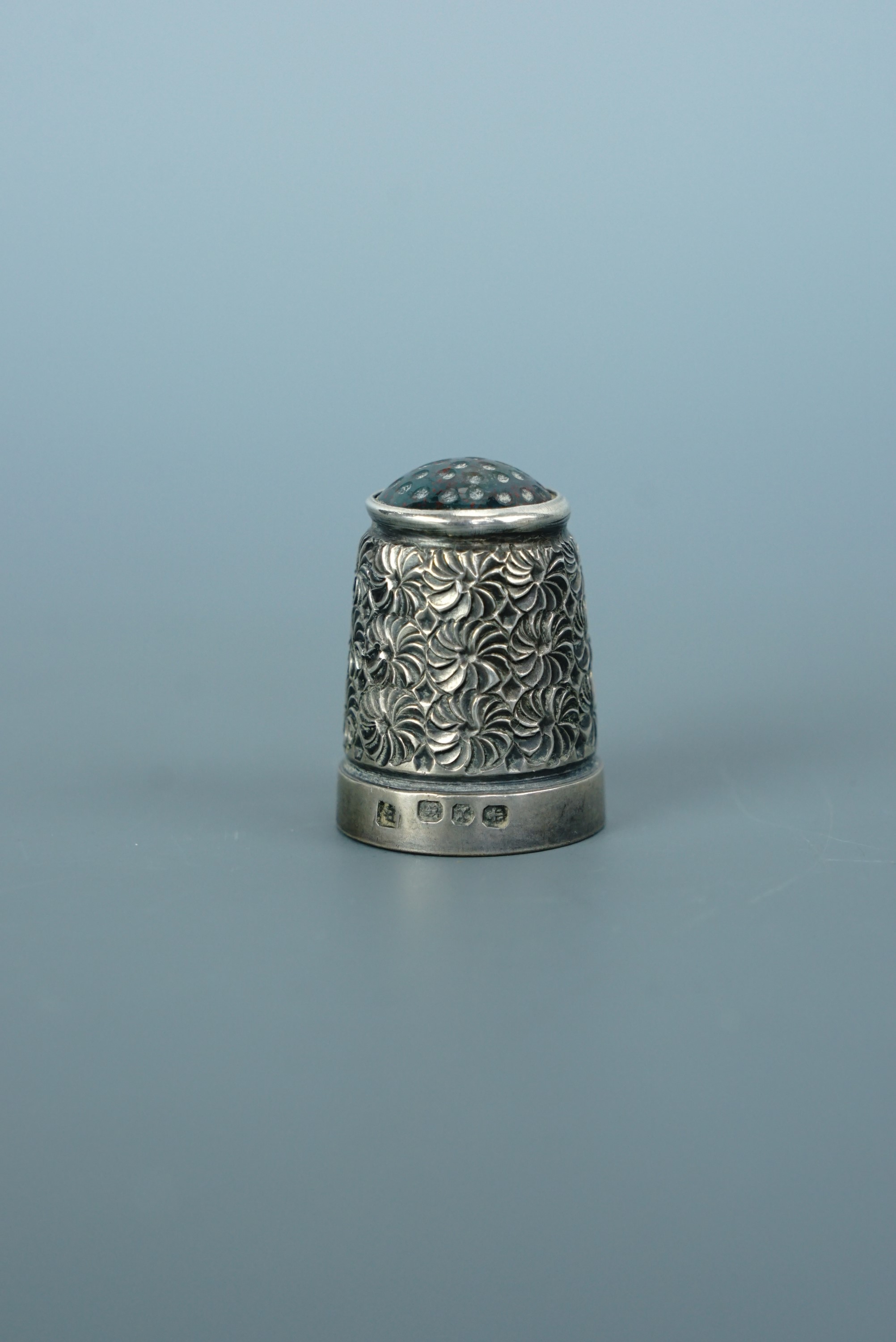A Victorian silver thimble with polished bloodstone top