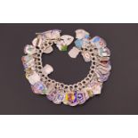 A silver / white metal charm bracelet bearing numerous enamelled shield-shaped town and city arms