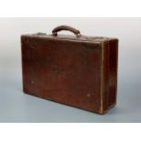 An antique hide suitcase bearing the embossed initials 'HT', 56 x 14 x 34 cm high