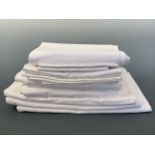 A quantity of antique and vintage white cotton bed linen, including pillow cases and a Plummers "