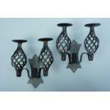 A contemporary pair of wrought iron candle sconces, each approximately 18 x 10 x 20 cm high