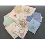 Vintage colourfully hand-embroidered tea linens, including tray liners, tea cloth, napkins and