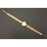 A lady's vintage 9ct gold cased Tissot wristlet watch on a 9ct gold bracelet strap, having a