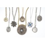 A collection of eight vintage medallion necklaces, some decorated with armorial crests, one in the
