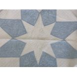 An early 20th Century patchwork quilt, worked in powder blue and white cotton, with central star