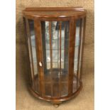 A bow-fronted glazed walnut display cabinet, circa 1930s - 1950s