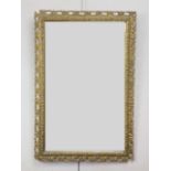 An antique gilt-framed wall mirror, having a reticulated and foliate moulded frame, 75 x 50 cm