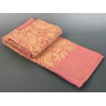 An antique patchwork quilt, of pink cotton and printed paisley, double sided, approximately 168 x