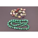 A single strand necklace of polished malachite beads, largest approximately 15 mm, smallest 10 mm,