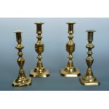 Two pair of Victorian brass candlesticks, 25 cm high and 22 cm high