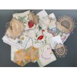 A quantity of vintage colourfully hand-embroidered tea table cloths and tray liners