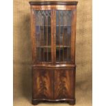 A reproduction Georgian serpentine-fronted and astragal-glazed mahogany corner cabinet