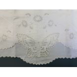 Antique embroidered pillow cases, including one with a cutwork butterfly, and a pair with floral