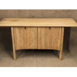 An Ercol Saville pattern elm sideboard, having a shaped plank top, over two cupboard doors and