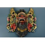 A large south Asian carved and gilt wooden mask placque, appr 50 cm x 55 cm