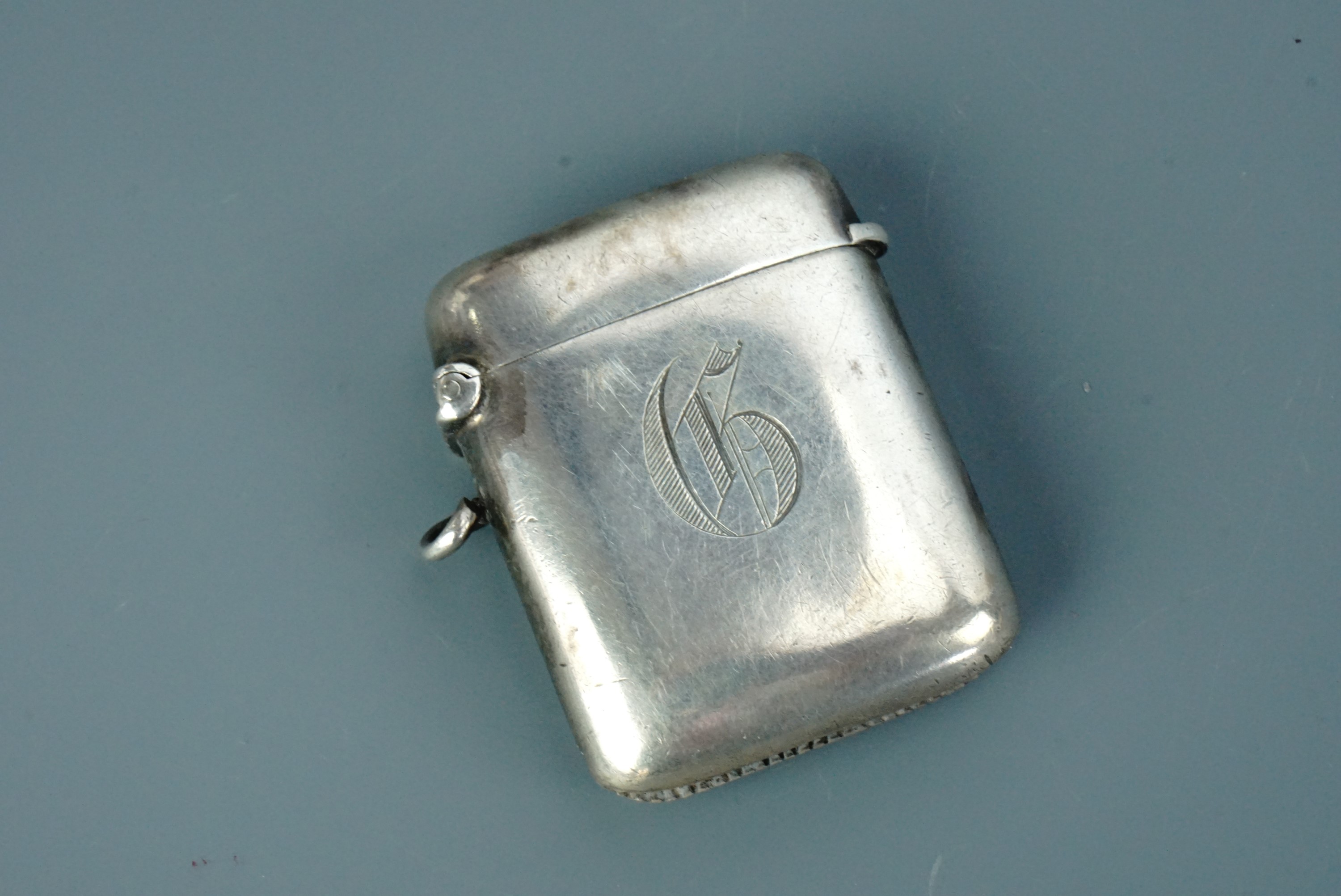 A late Victorian silver fob vesta case, of plain cushion form engraved with the Gothic initial G
