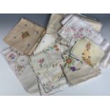 A group of vintage colourfully hand-embroidered tea table linens, including table cloths and
