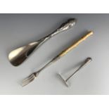 A silver pickle fork, a silver-handled shoe horn and a infant's silver pusher / feeder