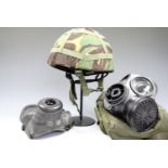 A British Military GS Mk I combat helmet together with two gas masks.