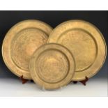 Three Chinese engraved brass trays / plaques, 51 cm and 36 cm