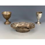 An antique Art Nouveau silver dish, together with a silver egg cup and miniature trophy cup, the