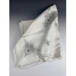 An antique luncheon or tea table cloth of Aesthetic influence, worked in taupe threads over white,